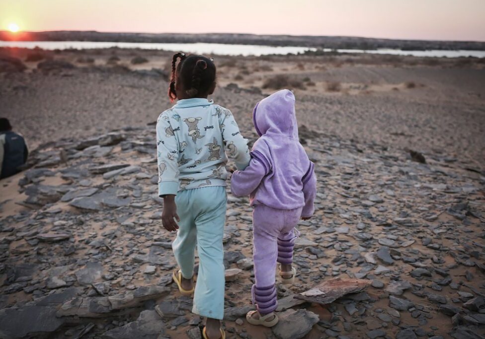 Children walk to the edge of the Nile at sunset, where Nubians used to have their homes, but no longer.